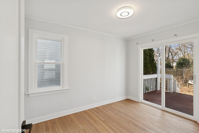 spare room with baseboards, light wood-type flooring, and ornamental molding