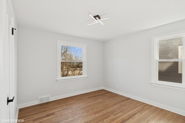 empty room with visible vents, baseboards, and light wood-style flooring