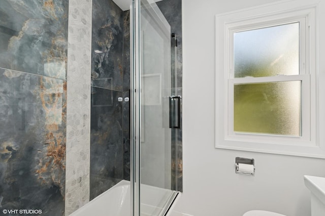 bathroom featuring combined bath / shower with glass door and toilet