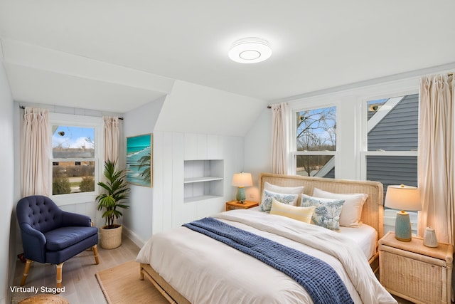 bedroom featuring vaulted ceiling, baseboards, and wood finished floors