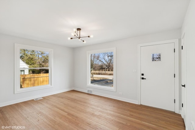 entryway with visible vents, plenty of natural light, and an inviting chandelier