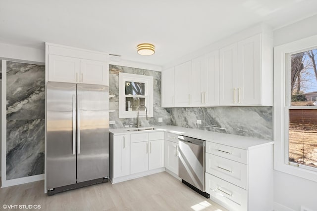 kitchen featuring a sink, white cabinetry, appliances with stainless steel finishes, and a healthy amount of sunlight