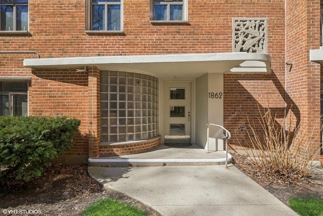 doorway to property with brick siding