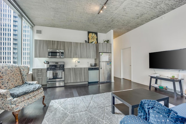 living area with dark wood-type flooring, rail lighting, and visible vents