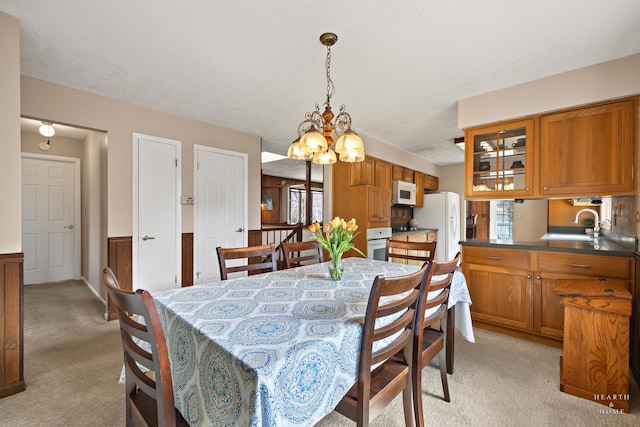 dining area with light carpet and a chandelier