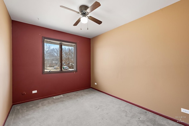 spare room with visible vents, ceiling fan, baseboards, and carpet