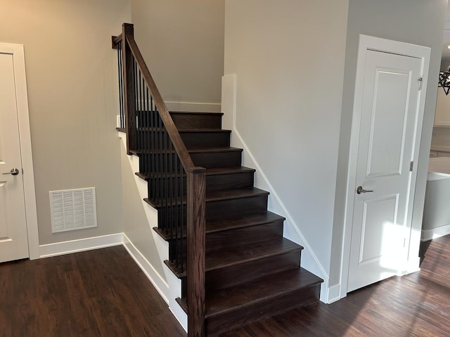 stairs featuring wood finished floors, visible vents, and baseboards