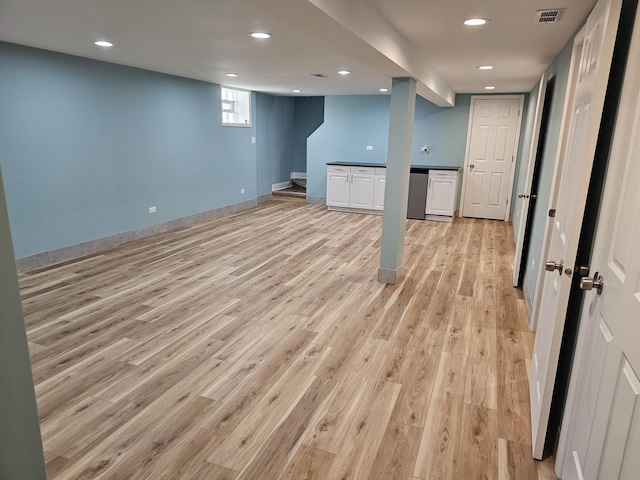 below grade area with visible vents, baseboards, stairs, light wood-type flooring, and recessed lighting