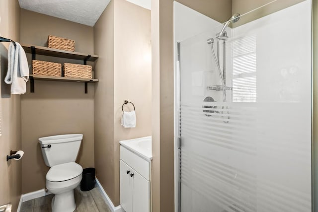 full bath with baseboards, vanity, toilet, and a shower stall