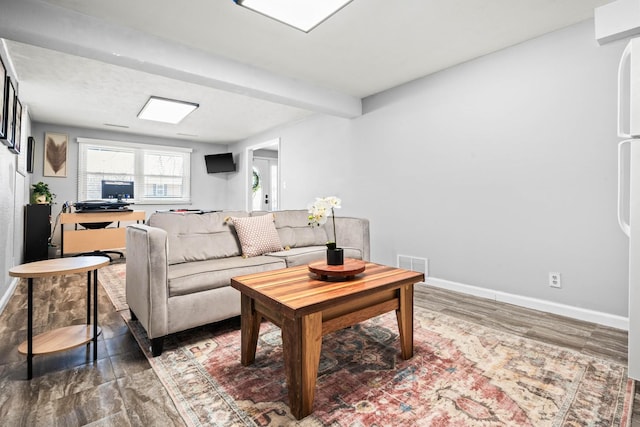 living room with visible vents, baseboards, and wood finished floors