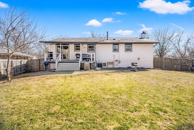 rear view of property featuring a lawn, a fenced backyard, cooling unit, a chimney, and a patio area