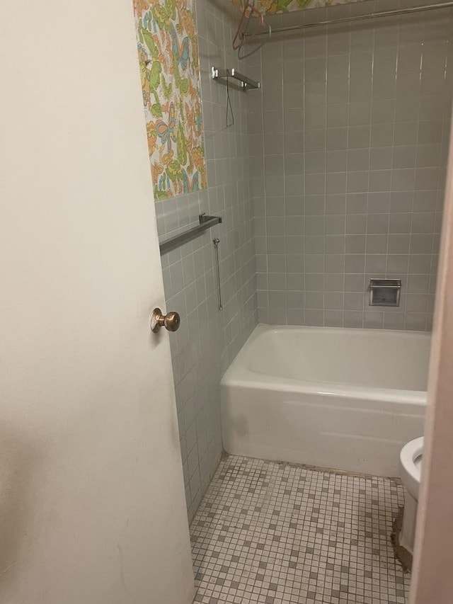 bathroom featuring toilet, shower / tub combination, and tile patterned flooring