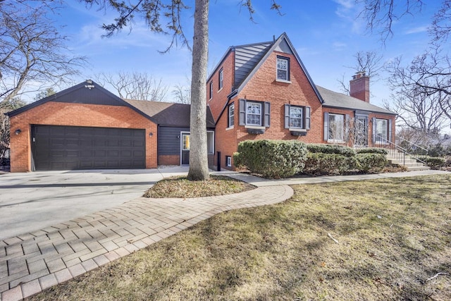 view of front of property with concrete driveway, a garage, brick siding, and a chimney