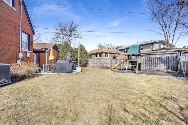 view of yard featuring cooling unit, a playground, and a fenced backyard