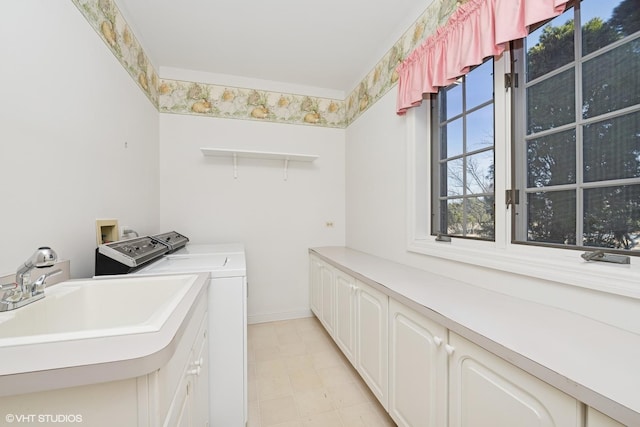 clothes washing area with a sink, cabinet space, independent washer and dryer, and baseboards