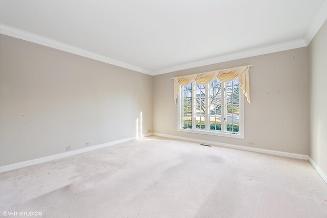 carpeted spare room with visible vents, crown molding, and baseboards