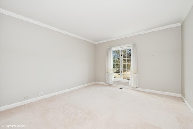 empty room featuring light carpet, baseboards, and ornamental molding