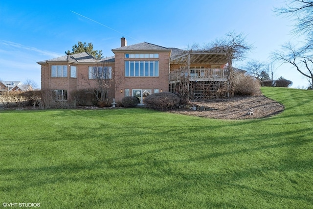 rear view of property featuring a yard and a chimney