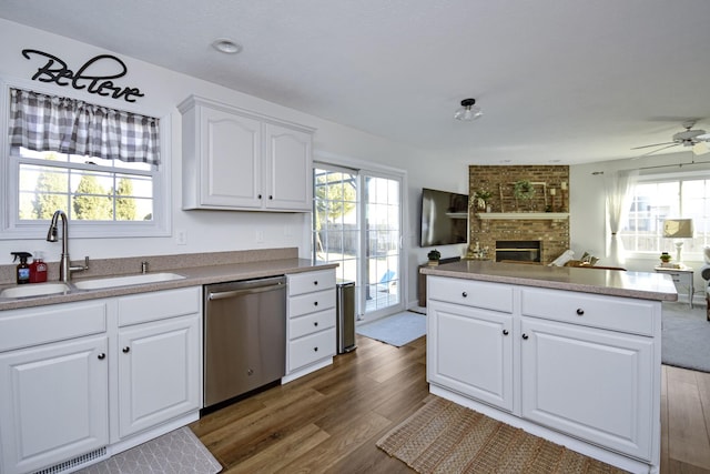 kitchen featuring dishwasher, dark wood finished floors, a wealth of natural light, and a sink