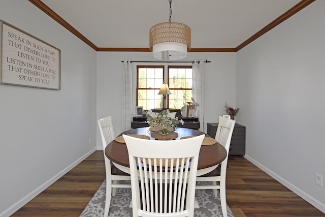 dining space featuring crown molding, baseboards, and wood finished floors