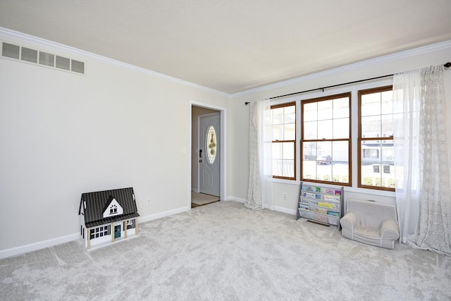 spare room with crown molding, carpet, baseboards, and visible vents