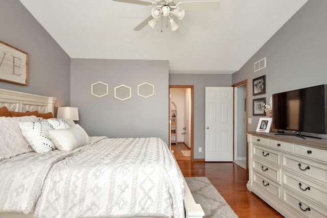 bedroom with visible vents, baseboards, lofted ceiling, wood finished floors, and a ceiling fan