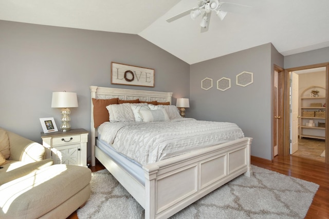 bedroom featuring vaulted ceiling, wood finished floors, baseboards, and ceiling fan