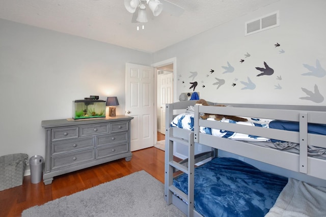 bedroom featuring visible vents, a ceiling fan, and wood finished floors