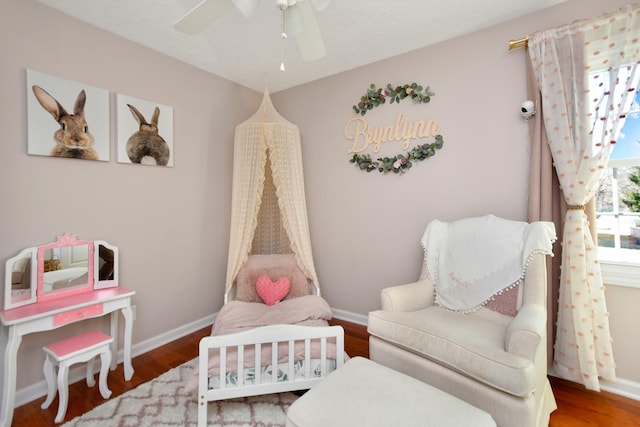 sitting room with wood finished floors, baseboards, and ceiling fan