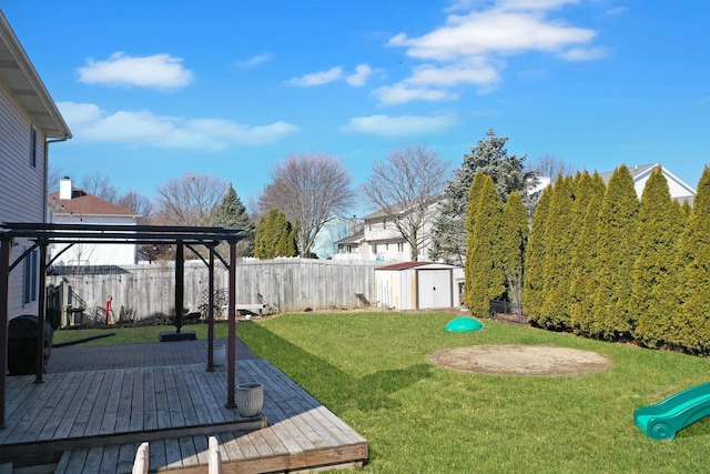 view of yard featuring a storage unit, an outbuilding, a deck, a pergola, and a fenced backyard