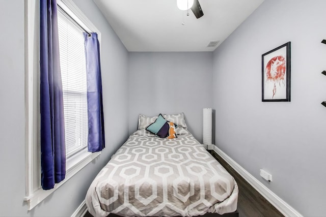 bedroom featuring visible vents, ceiling fan, baseboards, and wood finished floors