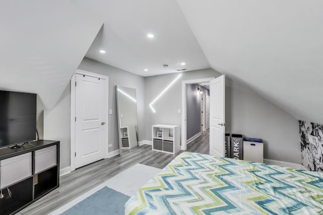 bedroom with recessed lighting, baseboards, lofted ceiling, and wood finished floors