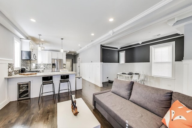 living room featuring beverage cooler, a wainscoted wall, and dark wood-style flooring