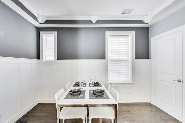 unfurnished dining area featuring visible vents, a healthy amount of sunlight, crown molding, and wood finished floors