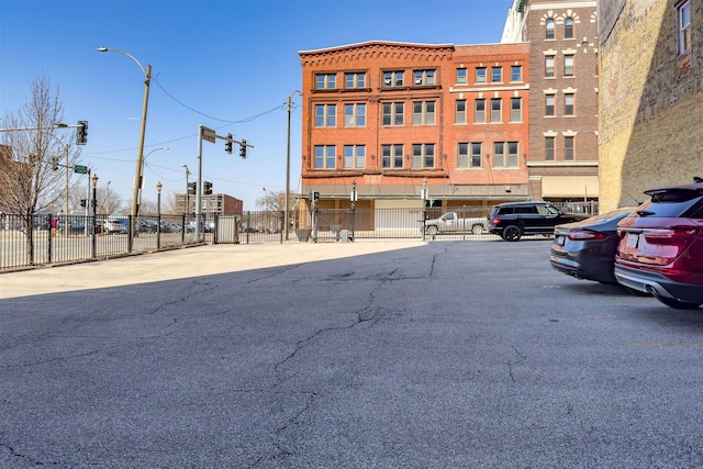 view of property with fence and uncovered parking