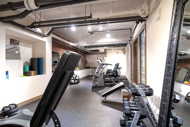 workout area featuring baseboards and a garage