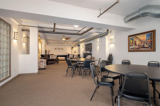 carpeted dining space featuring baseboards and ceiling fan