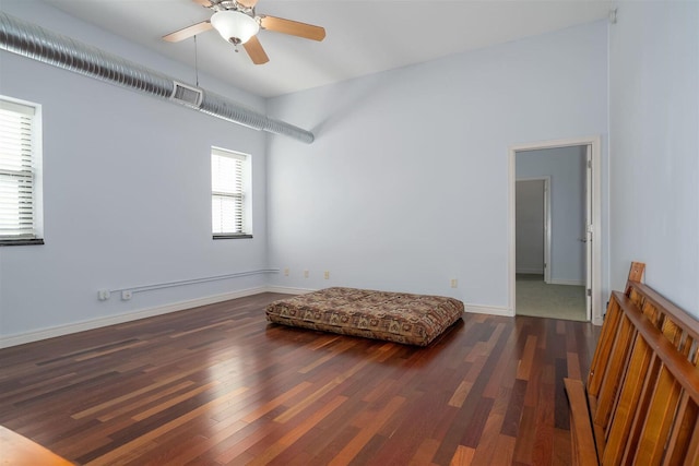 living area with baseboards, wood finished floors, visible vents, and ceiling fan