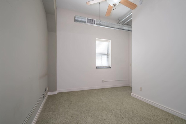 empty room featuring carpet flooring, visible vents, baseboards, and ceiling fan