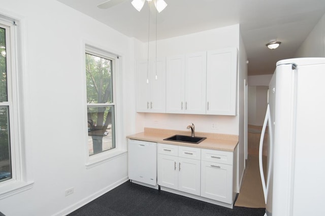 kitchen featuring white cabinets, white appliances, light countertops, and a sink