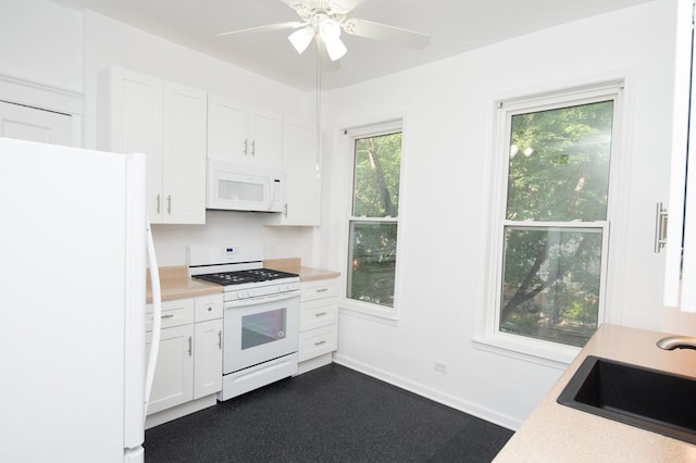 kitchen featuring a sink, white appliances, light countertops, and white cabinetry