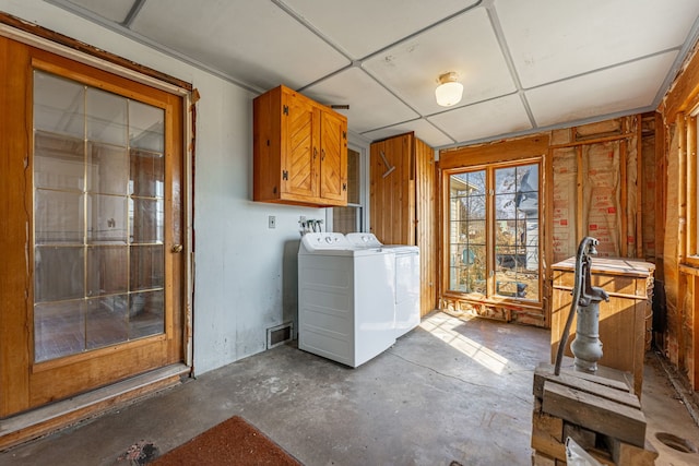 interior space with cabinet space, visible vents, and washing machine and clothes dryer