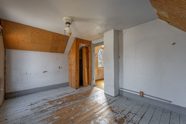 spare room featuring hardwood / wood-style floors and vaulted ceiling