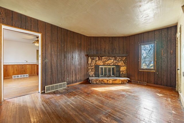 unfurnished living room featuring visible vents, hardwood / wood-style floors, and a fireplace