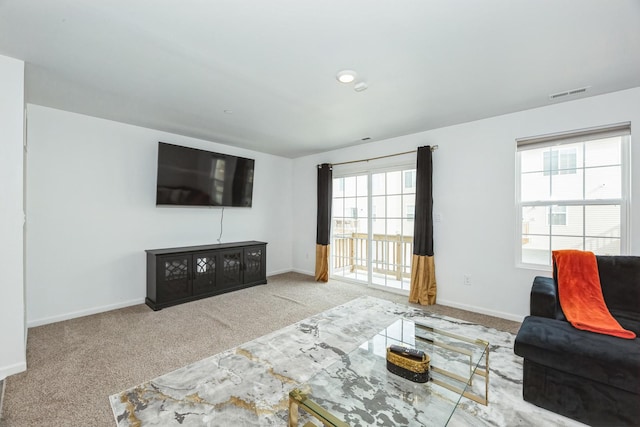 living area with carpet, visible vents, and baseboards