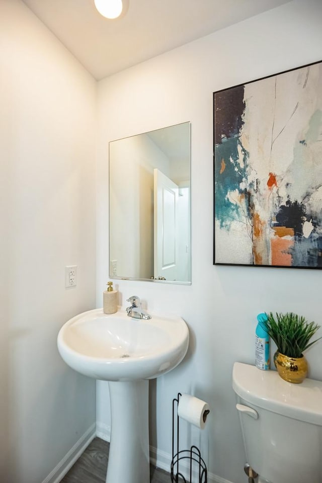 bathroom with toilet and baseboards