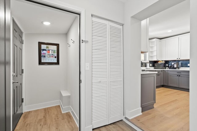 corridor featuring recessed lighting, baseboards, and light wood-style flooring