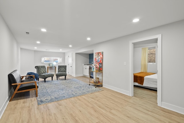 living area with light wood-style flooring, recessed lighting, visible vents, and baseboards