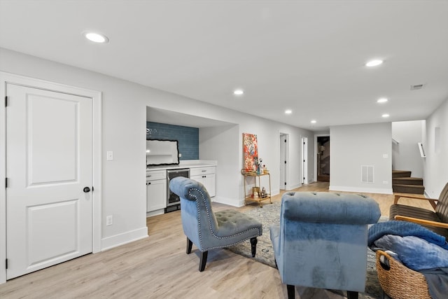 living room featuring recessed lighting, light wood-type flooring, and stairs