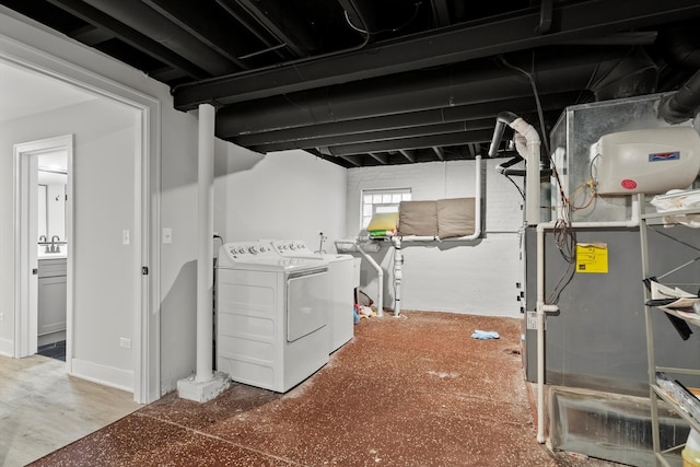 washroom with laundry area, heating unit, and washing machine and dryer